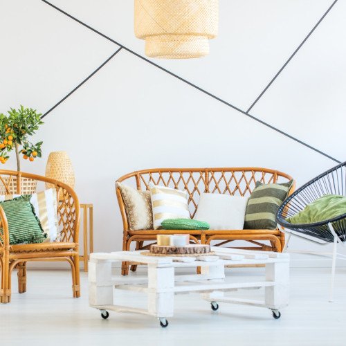 Trendy living room with modern furniture, plants and decorative tape on the wall